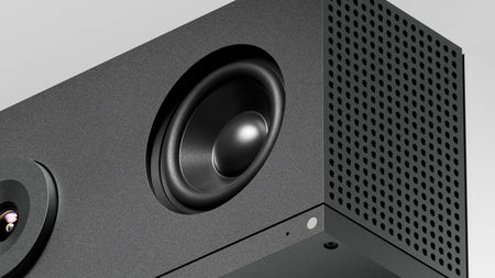 Close-up of a black speaker with a detailed view of the cone and grille.