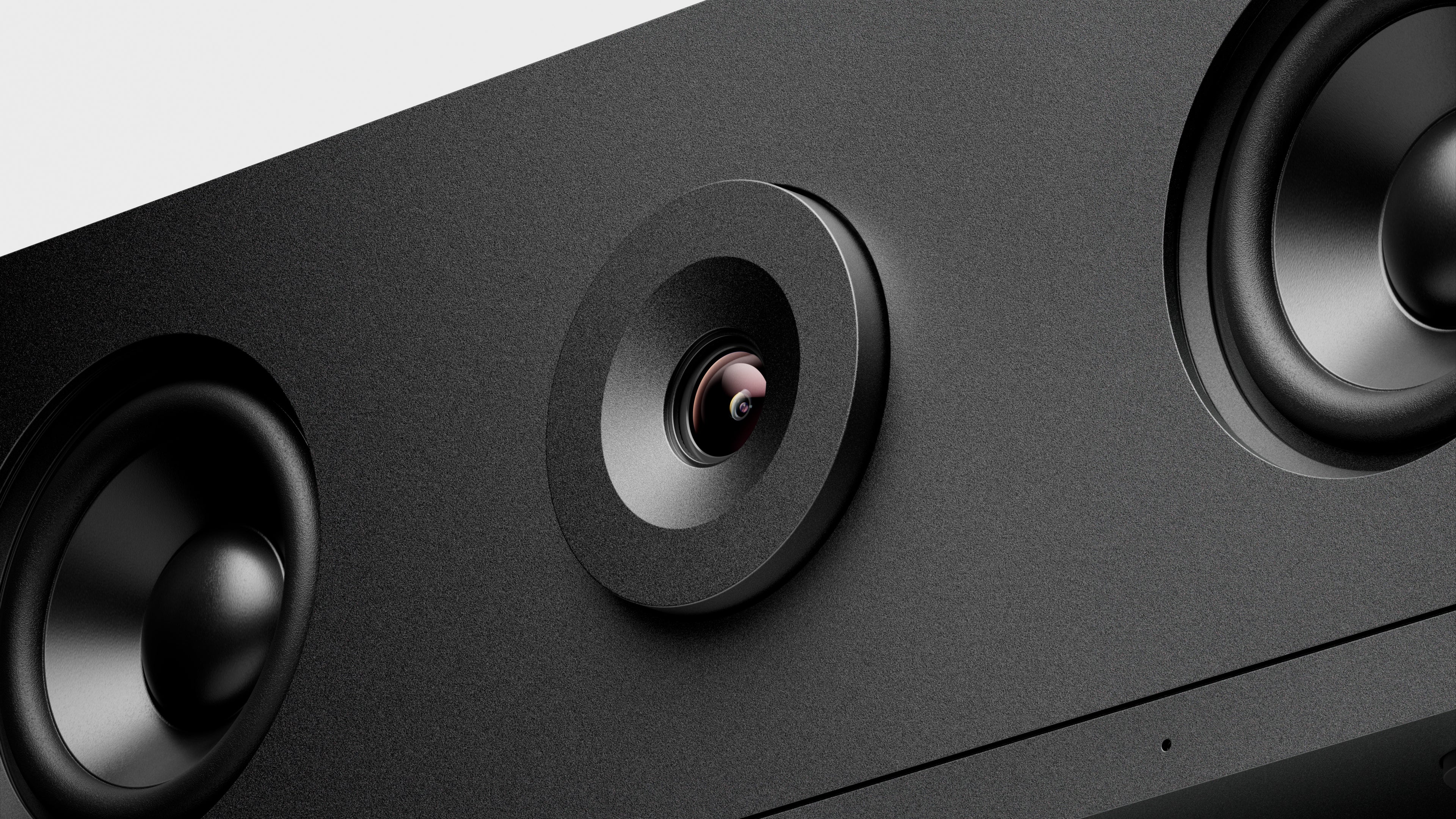 Close-up of a black electronic device with a camera lens and speakers.